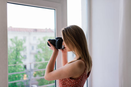 Freelance photographer woman with camera at home office editing photos on computer
