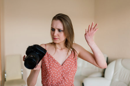 Freelance photographer woman with camera at home office editing photos on computer