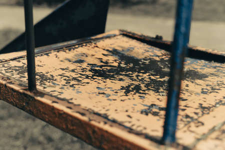 The old childrens slide stands on the playground tightened by fog aloone. Yellow paint peeled off.の写真素材