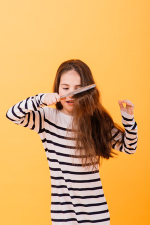 Portrait of a beautiful and confident girl showing emotions isolated on yellow, studioの写真素材