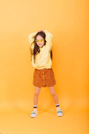 Portrait of a beautiful and confident girl showing emotions isolated on yellow, studioの写真素材