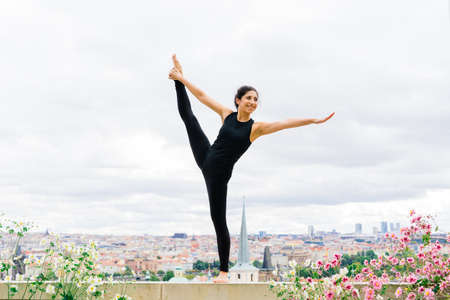 Healthy woman in a sportswear practicing yoga outdoor, doing exercise, full length portrait.の写真素材