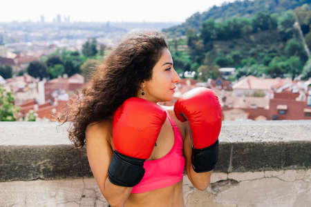 Photo of strong fitness woman boxer in gloves posing outdoors.の写真素材