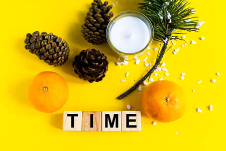 Word TIME on wooden blocks on a yellow background with tangerine. Healthy food conceptの写真素材