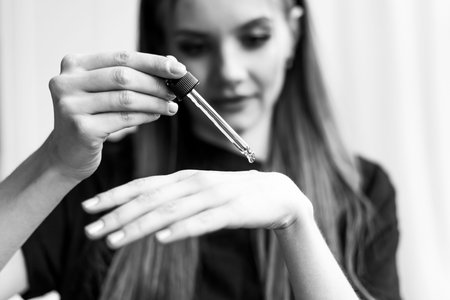 Girl touching her hair and smiling while posing at interior looking in mirror