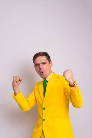 Portrait of happy confident businessman in yellow suit and tie, isolated on white background.の写真素材