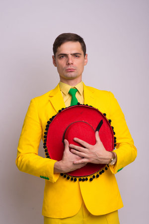 Portrait of happy confident businessman in yellow suit and tie, isolated on white background.の写真素材