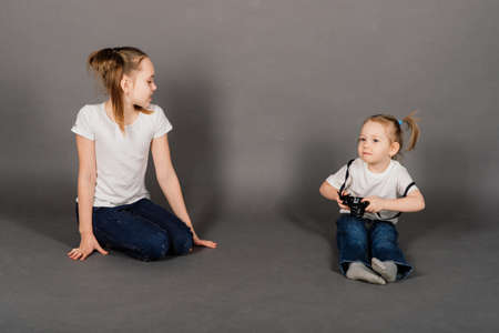 Sister taking photo with the camera of her sister in studioの写真素材