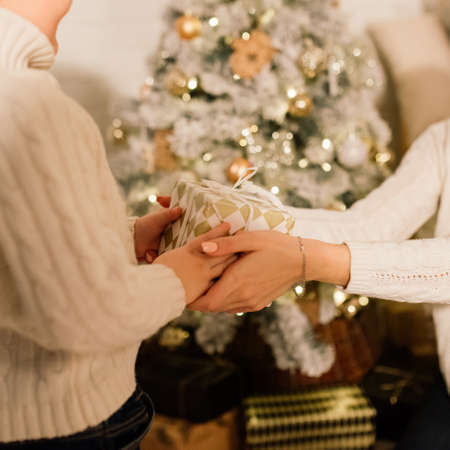 Happy family mother, daughter and son at a christmas tree at homeの写真素材