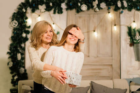 Happy family mother, daughter and son at a christmas tree at homeの写真素材