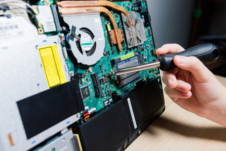 Bratislava, Slovakia - 12.14.2021. Service engineer install new chips to laptop. Repairing and...