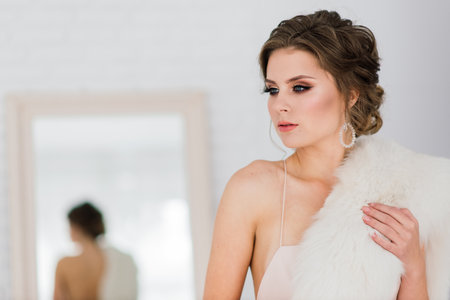 Bratislava, Slovakia - 08.08.2021. Bride in beautiful dress indoors in white studio interior like at home.のeditorial素材