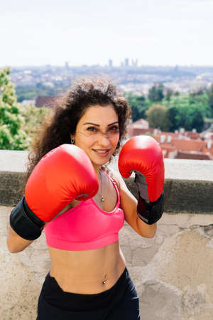 A woman boxer training outdoor - city and nature in a backgroundの写真素材
