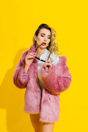 Young woman in a white bodysuit posing on studio background. Female fashion, beauty and body conceptの写真素材