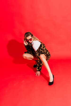 Gorgeous young woman posing in a luxurious fur coat and bodysuit. Fashion, beauty. Studio shot.の写真素材