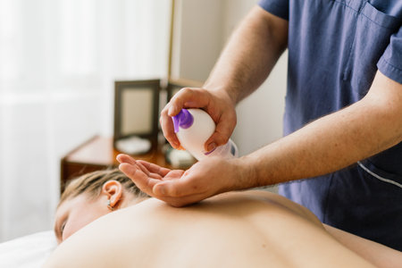 Plump woman getting hot stones arm massage in spa salon. Therapy, wellness and relaxation conceptの写真素材