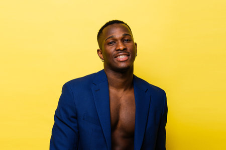 Guy in blue suit on a yellow background. Handsome athletic man in jacket smilingの写真素材