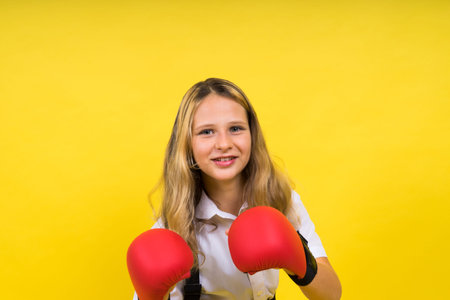 An adorable little girl boxer practicing punches in studioの写真素材