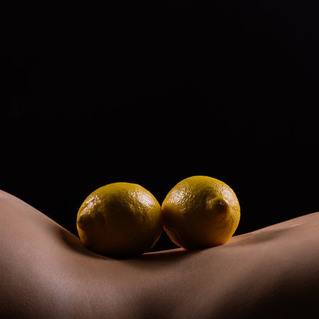 Lemon, natural vitamin c help skin whitening. Naked woman lying on her back with fruit locatedの写真素材