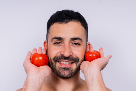 Full isolated studio picture from a young naked man with underwear and tomatoの写真素材