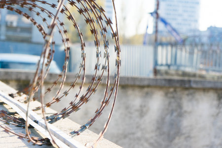 Barbered wire over a blue sky and on building ground, rustyの写真素材