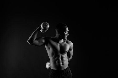 Muscular black african man with defined muscles abs abdominal, exercise determination and successの写真素材