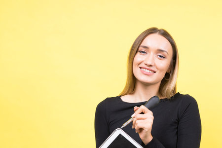 Service center. Laptop Repair. Female screwdriver unscrews laptop bolts on yellow backgroundの写真素材