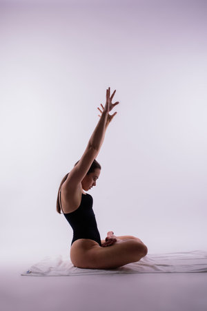 Young beautiful yoga female posing on a studio backgroundの写真素材