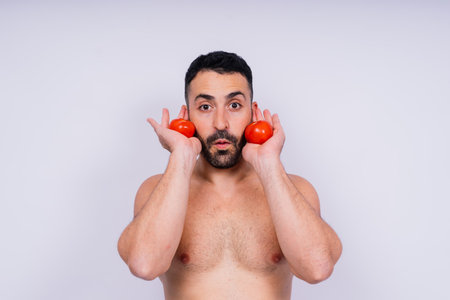 Full isolated studio picture from a young naked man with underwear and tomatoの写真素材