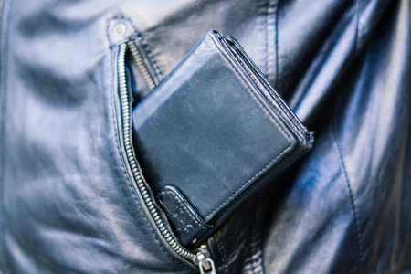 From the pocket of jacket the thief pulls out a card banknote money purse wallet.の写真素材