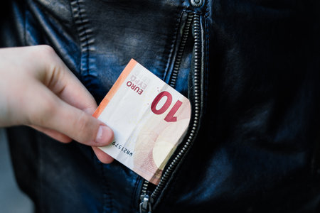 From the pocket of jacket the thief pulls out a card banknote money purse wallet.の写真素材