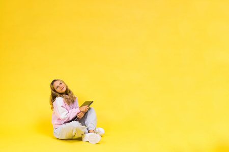 Positive kid sit with laptop read homework wear casual style cloth isolated over yellow background