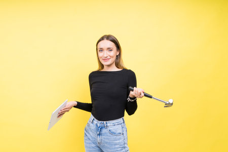 Service center. Laptop Repair. Female screwdriver unscrews laptop bolts on yellow backgroundの写真素材