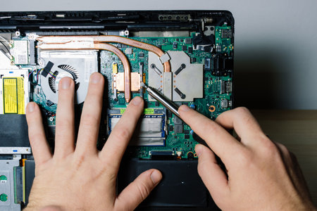 Prague, Czechia - 7th May 2022 Service engineer install new chips to laptop. Repairing laptop.のeditorial素材