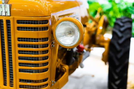 Small yellow tractor in exhibition, closeup details, wheelsの写真素材
