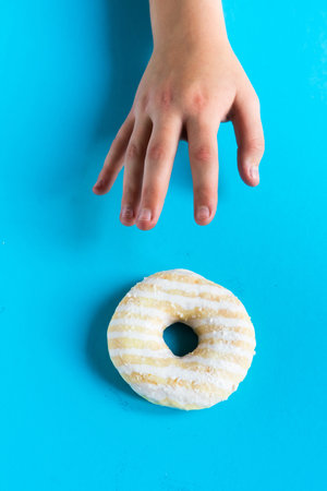Donut with hazelnuts on blue background, close upの写真素材