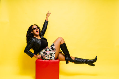Seductive african woman posing in a black bodysuit and jacket in studio. Fit sporty female.の写真素材