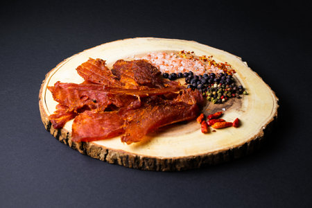 Beef jerky pieces isolated on a white and black backgroundの写真素材