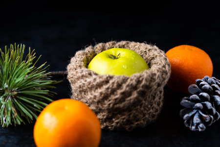 Tangerines and apples in baskets and peeled tangerine slices on the table.の写真素材