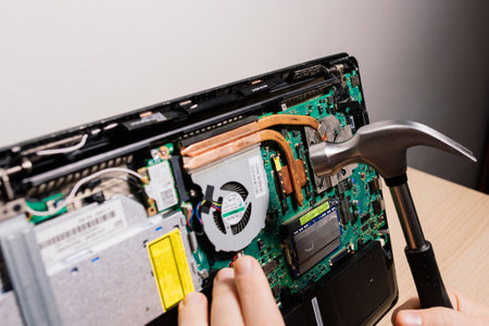 Prague, Czechia - 7th May 2022 Hand technician repairing broken laptop notebook computer with a screwdriverのeditorial素材
