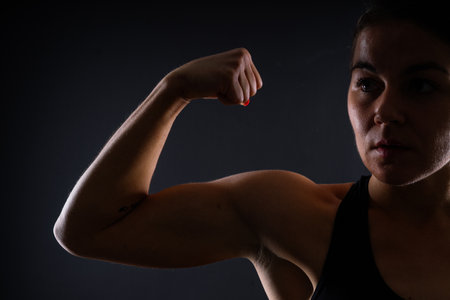 Close up of woman back with her muscles after workout. Female bodybuilder with perfect bicepsの写真素材