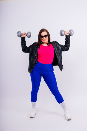 Sporty plump woman doing exercises with dumbbells. Sports motivation and healthy lifestyleの写真素材