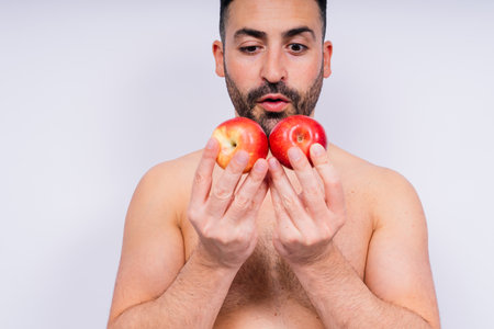 Man, hands and holding apple on white background in studio for health, wellness or immune support.の写真素材