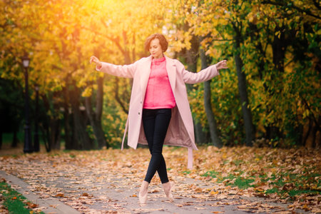 Ballerina dancing in nature among autumn leaves.の写真素材