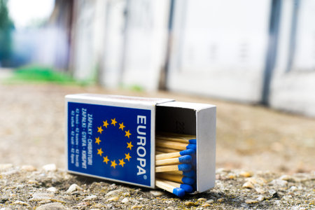 A match, a hand with a matches against the background of old garages in city.の写真素材