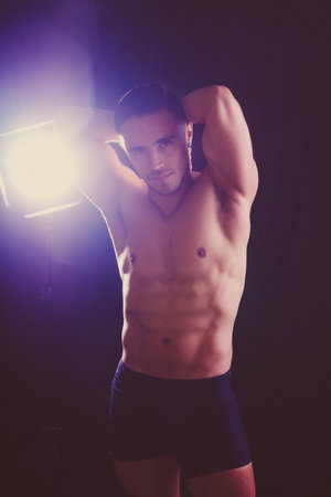 Confident, attractive shirtless muscular young man topless in studioの写真素材