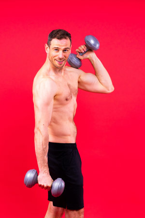 Handsome young fitness sporty strong guy bare-chested muscular sportsman on studio backgroundの写真素材