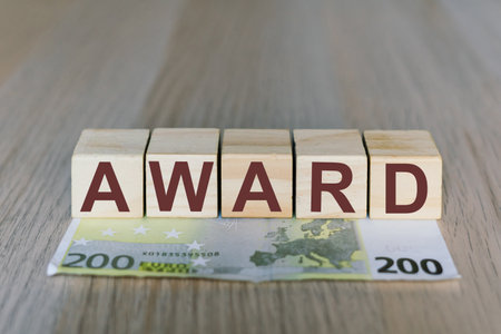 Award word on wooden cubes blocks, money 200 Euro banknotes. Management big salary career concept.の写真素材