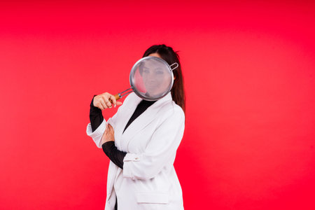 Female with metal sieve for sifting flour in a female hand on red and white background.
