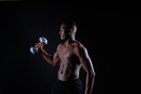 Young man with dumbbells good physique isolated on red and black background. Strength and motivationの写真素材